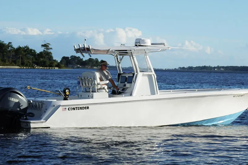 Slide: The Image of 2023 Contender 30 Tournament boat cruising on a calm lake with a Yamaha engine. - 3