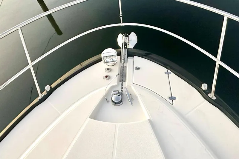 Slide: The Image of 2013 Monterey 400 Sport Yacht bow with anchor and railing, docked on calm water. - 7