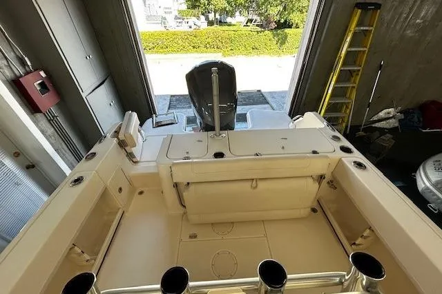 Slide: The Image of 2019 Grady-White Fisherman 236 boat interior, showing seating and storage in a garage setting. - 12