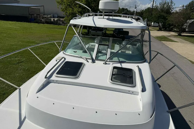 Slide: The Image of 2000 Glacier Bay 2670 Island Runner boat, white exterior, docked on a sunny day. - 13