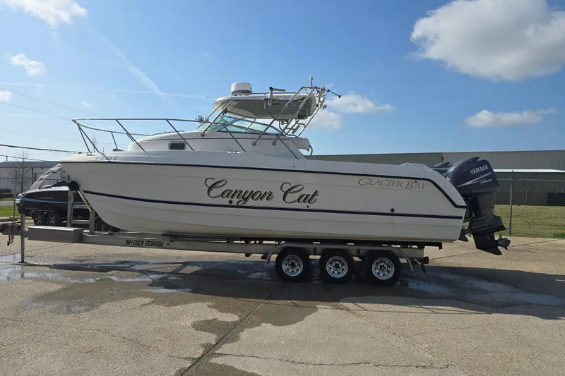Slide: The Image of 2000 Glacier Bay 2670 Isle Runner boat on trailer under clear sky. - 19