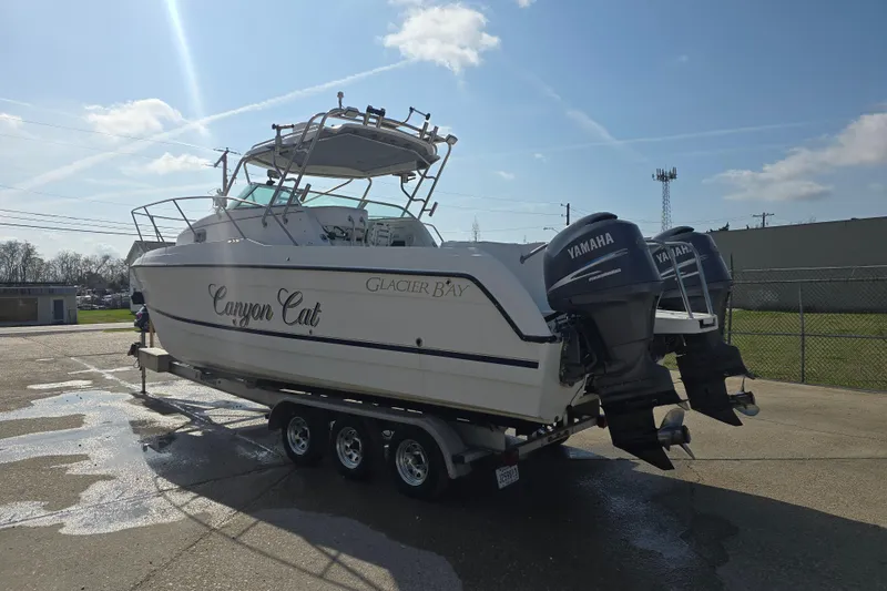 Slide: The Image of 2000 Glacier Bay 2670 Isle Runner boat with dual Yamaha engines on a trailer. - 20