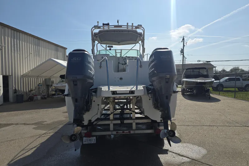 Slide: The Image of 2000 Glacier Bay 2670 Isle Runner with dual Yamaha 150 engines in a boatyard. - 21