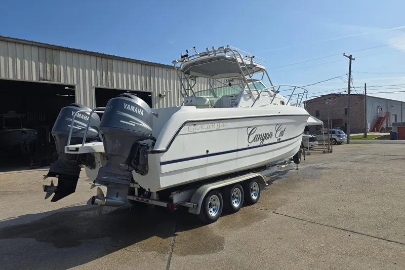 Slide: The Image of 2000 Glacier Bay 2670 Isle Runner boat with dual Yamaha engines on a trailer. - 26
