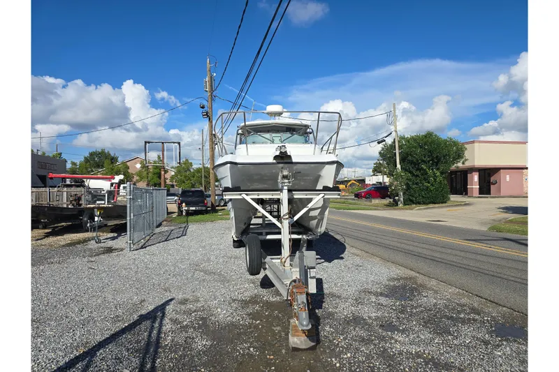 Slide: The Image of 2000 Glacier Bay 2670 Island Runner boat on trailer, parked on gravel lot under blue sky. - 7