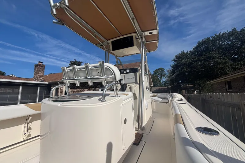Slide: The Image of 2015 Pioneer 222 Sportfish boat with T-top and rod holders, docked in a residential area. - 10