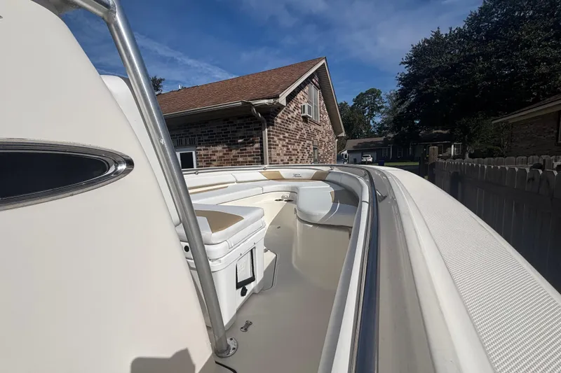 Slide: The Image of 2015 Pioneer 222 Sportfish boat parked beside a brick house under a clear blue sky. - 11