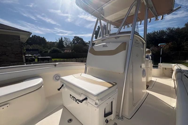 Slide: The Image of 2015 Pioneer 222 Sportfish boat with T-top and seating, under a sunny sky. - 14