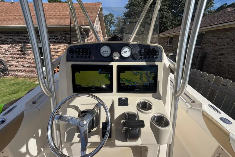 Slide: The Image of 2015 Pioneer 222 Sportfish boat dashboard with steering wheel and navigation screens. - 15