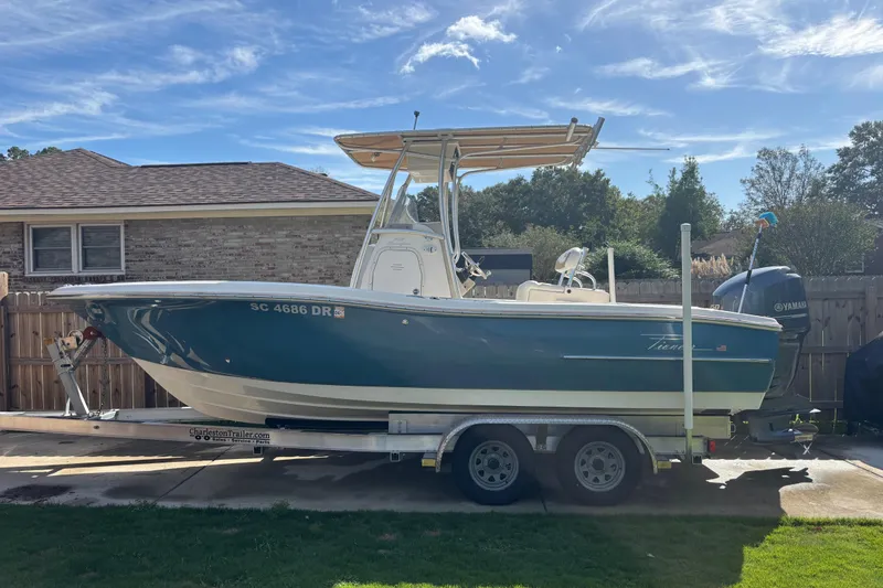 Slide: The Image of 2015 Pioneer 222 Sportfish boat on trailer, parked in driveway under clear sky. - 4