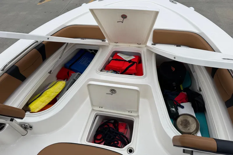 Slide: The Image of 2024 Robalo 226 Cayman boat storage compartments with safety gear and equipment. - 12
