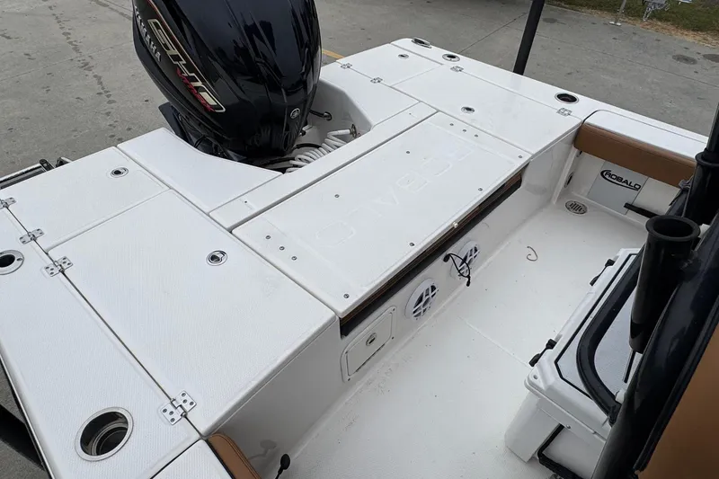 Slide: The Image of 2024 Robalo 226 Cayman boat deck with Yamaha engine, featuring storage compartments and rod holders. - 17