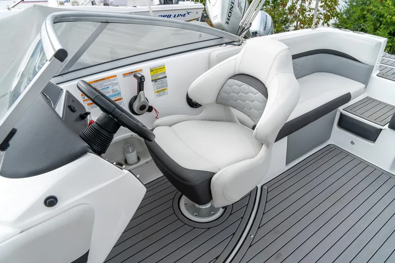 Slide: The Image of 2024 Hurricane SunDeck 217 OB boat interior with sleek seating and modern steering console. - 18