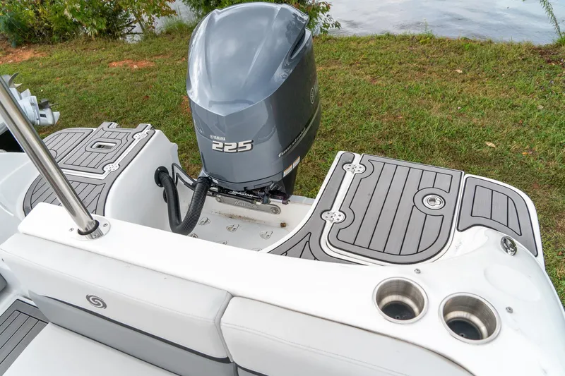 Slide: The Image of 2024 Hurricane SunDeck 217 OB boat with Yamaha 225 outboard motor, docked by a grassy shore. - 23