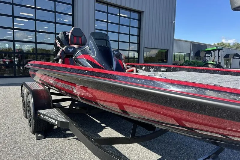 Slide: The Image of 2026 Phoenix 920 Elite boat with sleek red design, parked outside a modern building. - 3