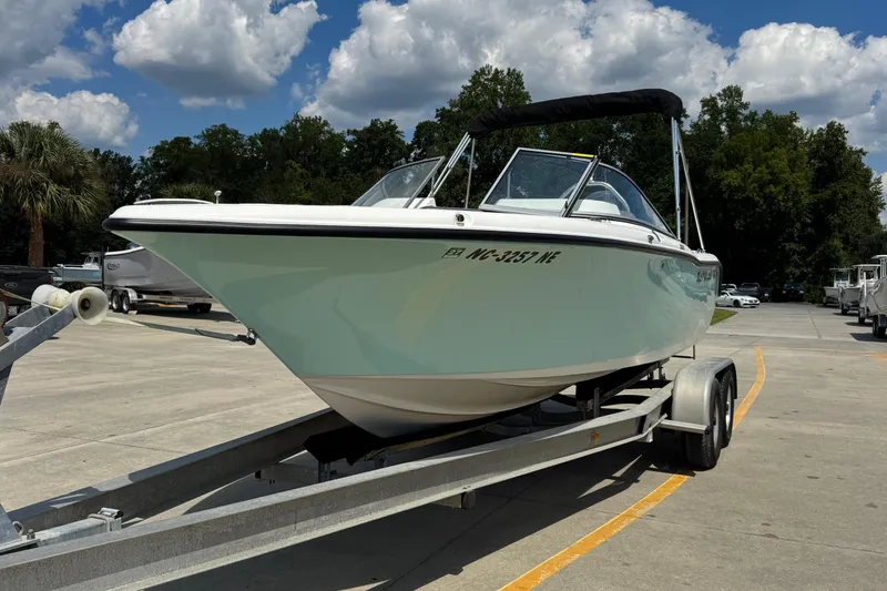 Slide: The Image of 2025 Key West 203 DFS boat on trailer under a partly cloudy sky. - 1