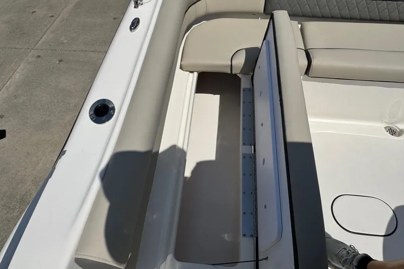 Slide: The Image of 2025 Key West 203 DFS boat interior with open storage compartment and cushioned seating. - 19