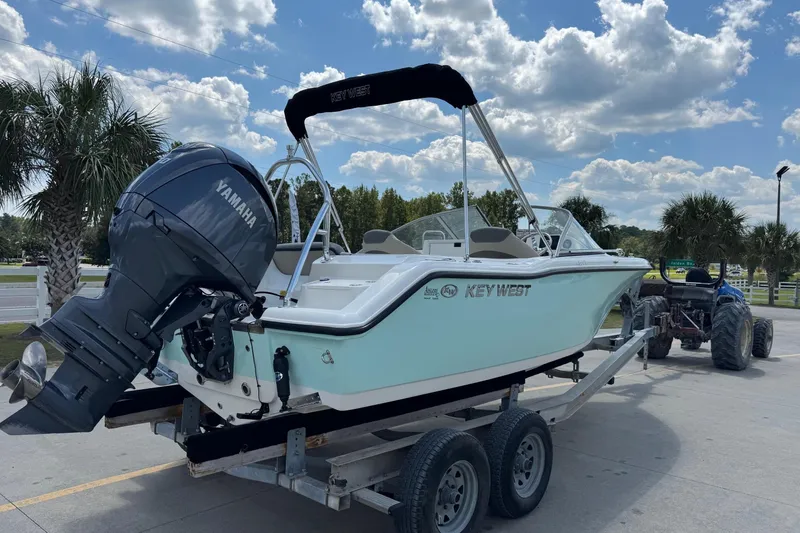 Slide: The Image of 2025 Key West 203 DFS boat on trailer with Yamaha engine, under a partly cloudy sky. - 5