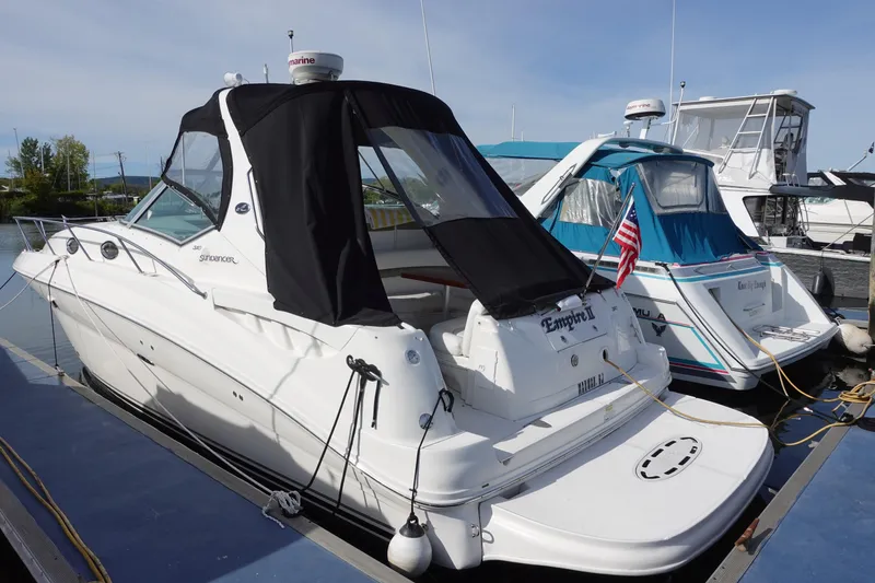 Slide: The Image of 2007 Sea Ray 320 Sundancer docked at marina, featuring sleek design and American flag. - 1