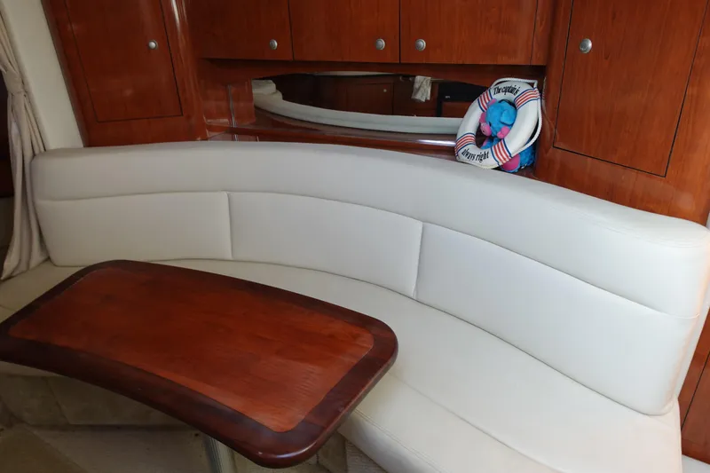 Slide: The Image of Luxurious interior of 2007 Sea Ray 320 Sundancer with white seating and wooden table. - 19