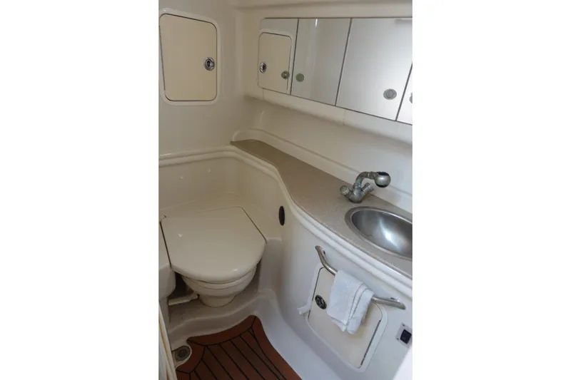 Slide: The Image of 2007 Sea Ray 320 Sundancer bathroom with sink, toilet, and storage cabinets. - 24