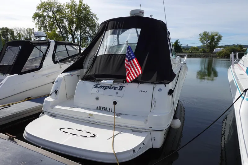 Slide: The Image of 2007 Sea Ray 320 Sundancer docked with American flag, rear view. - 6