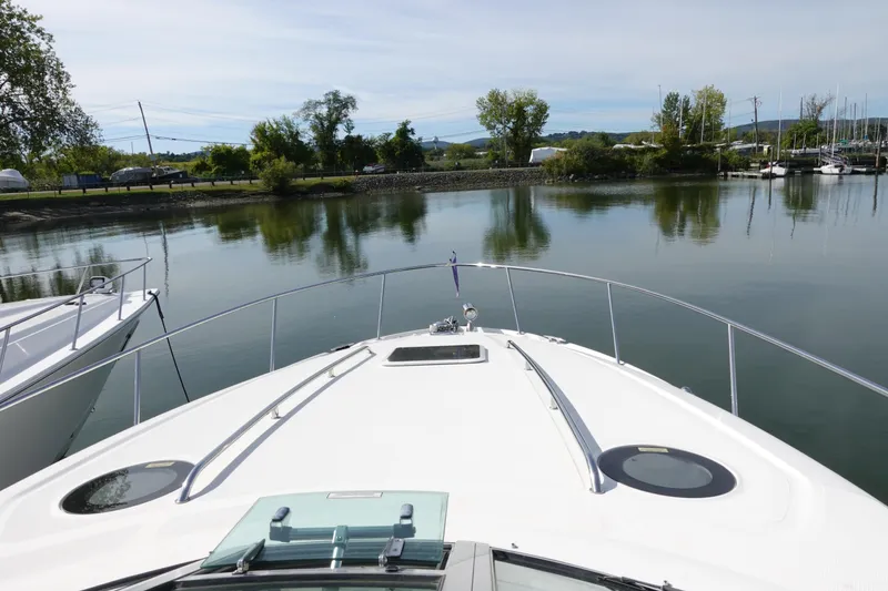 Slide: The Image of 2007 Sea Ray 320 Sundancer cruising on a calm lake with scenic shoreline views. - 7