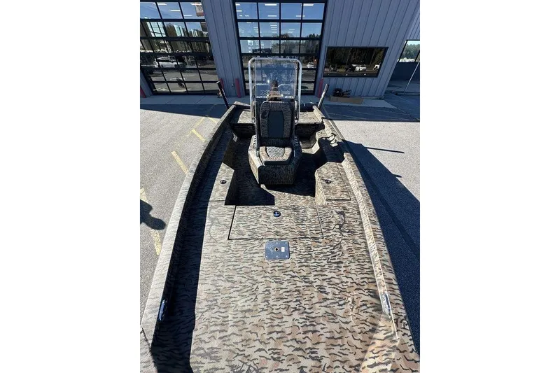 Slide: The Image of 2026 Xpress H20B Bay boat with camouflage design, parked outside a building. - 13