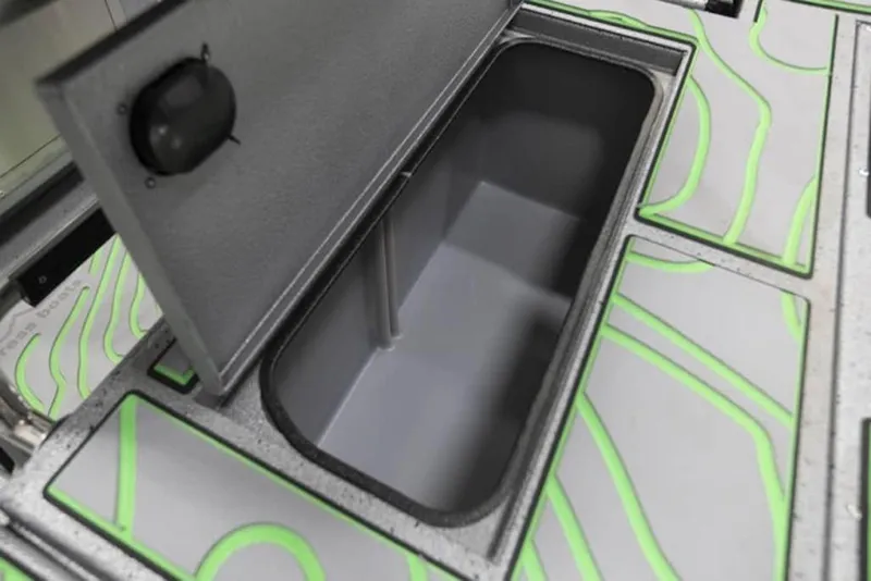 Slide: The Image of Open storage compartment in 2026 Xpress H20B Bay boat with green accents. - 24