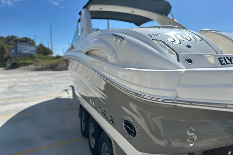 Slide: The Image of 2007 Sea Ray 290 SLX boat on trailer under clear blue sky. - 15