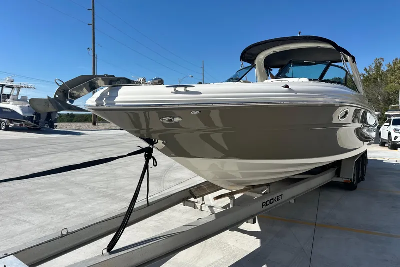 Slide: The Image of 2007 Sea Ray 290 SLX boat on trailer, parked outdoors under clear blue sky. - 28