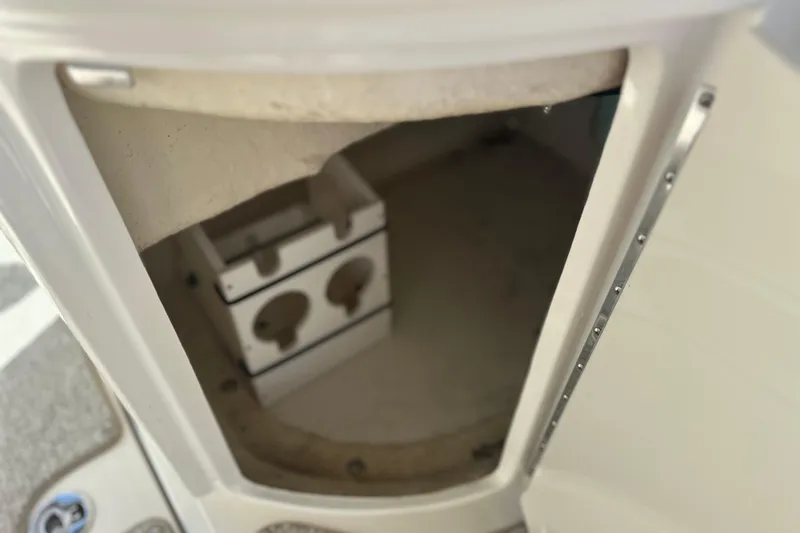 Slide: The Image of Storage compartment inside a 2007 Sea Ray 290 SLX boat, featuring cup holders. - 40