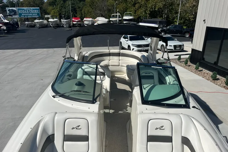 Slide: The Image of 2007 Sea Ray 290 SLX boat with open seating, parked outdoors at a marina. - 59