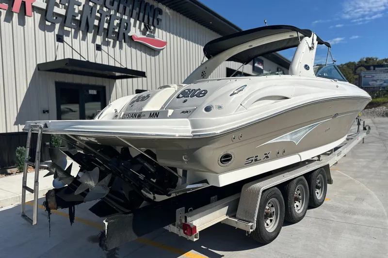 Slide: The Image of 2007 Sea Ray 290 SLX boat on trailer at a marine center. - 6
