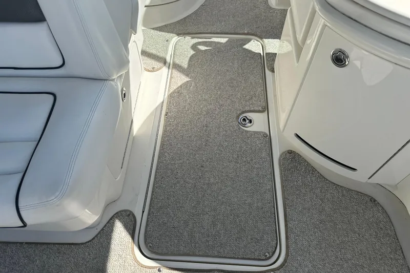 Slide: The Image of 2007 Sea Ray 290 SLX interior with gray carpet and white seating. - 68