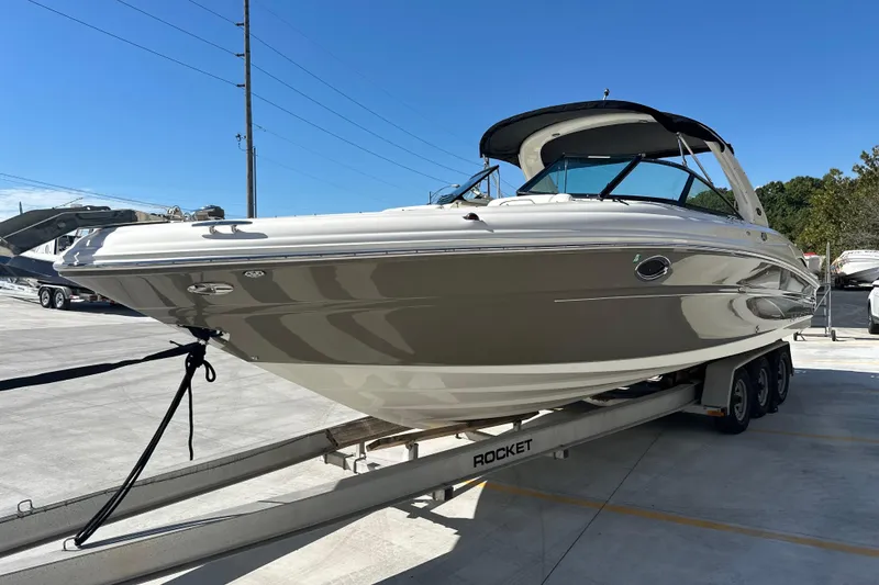 Slide: The Image of 2007 Sea Ray 290 SLX boat on trailer in sunny marina setting. - 7