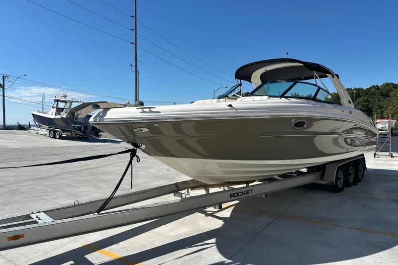 Slide: The Image of 2007 Sea Ray 290 SLX boat on trailer under clear blue sky. - 8