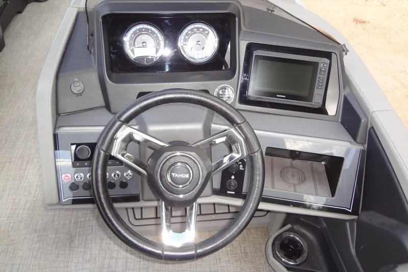 Slide: The Image of 2024 Tahoe Pontoon 2585 VRL dashboard with steering wheel, gauges, and navigation display. - 25
