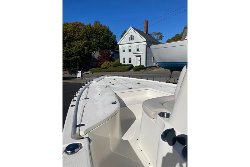 Slide: The Image of 2021 Sea Born FX21 Bay boat parked near a house under clear blue sky. - 2