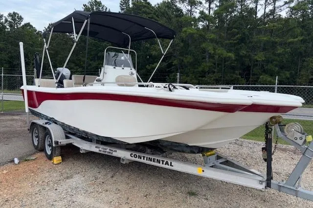 Slide: The Image of 2011 NauticStar 210 Coastal boat on trailer with canopy, parked outdoors. - 0