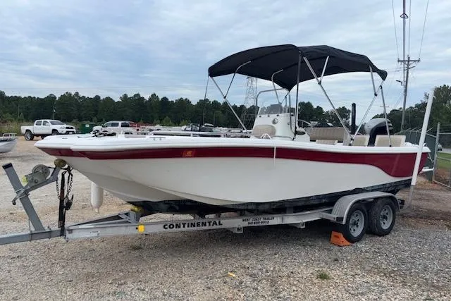 Slide: The Image of 2011 NauticStar 210 Coastal boat on trailer with canopy, parked outdoors. - 1
