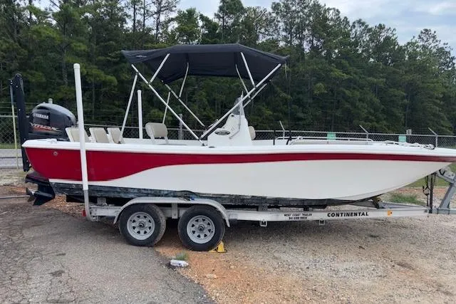 Slide: The Image of 2011 NauticStar 210 Coastal boat on trailer, featuring red and white design with canopy. - 2