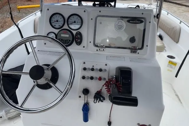 Slide: The Image of 2011 NauticStar 210 Coastal boat dashboard with steering wheel and control panel. - 20