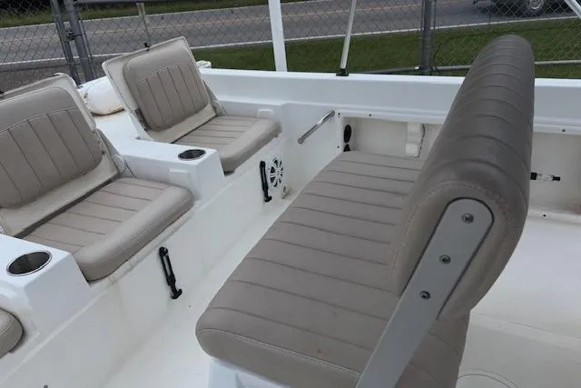 Slide: The Image of 2011 NauticStar 210 Coastal boat interior with beige seating and cup holders. - 21