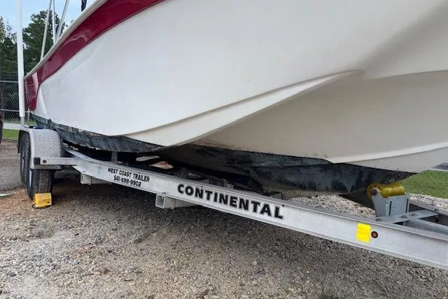 Slide: The Image of 2011 NauticStar 210 Coastal boat on Continental trailer, parked on gravel. - 23