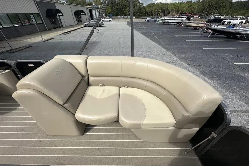 Slide: The Image of 2018 Manitou 23 Aurora LE RF boat with beige seating, parked in a lot. - 13