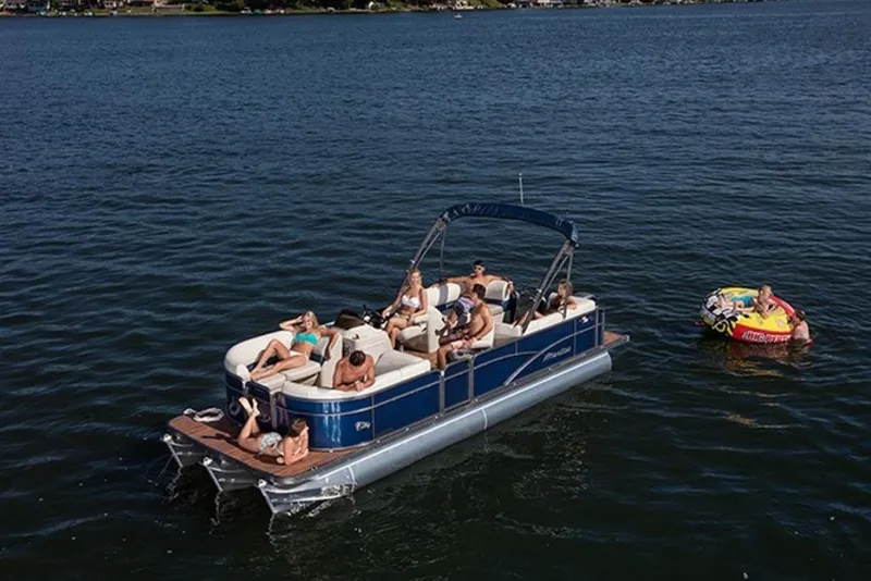 Slide: The Image of 2018 Manitou 23 Aurora LE RF pontoon boat with passengers enjoying a sunny day on the water. - 15