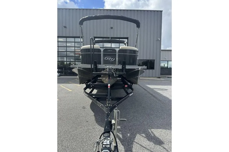 Slide: The Image of 2018 Manitou 23 Aurora LE RF pontoon boat on trailer, parked outside a building. - 5