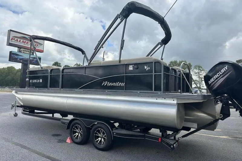 Slide: The Image of 2018 Manitou 23 Aurora LE RF pontoon boat on trailer, with Mercury outboard motor. - 6