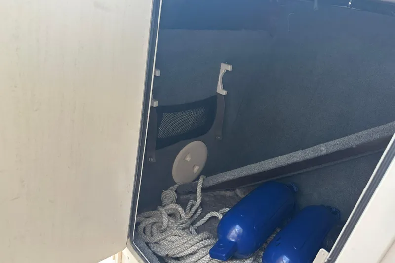 Slide: The Image of Storage compartment of 2012 Grady-White Freedom 275 boat with ropes and blue fenders. - 17